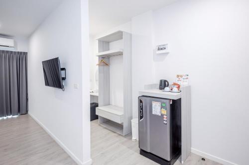 a kitchen with a refrigerator in a room at GRAND PA Hotel&Resort Lamphun Chiang Mai in Lamphun