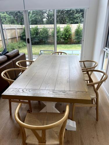 a wooden table and chairs in a living room at Laguna Beach House Ocean Grove-pets welcome in Ocean Grove