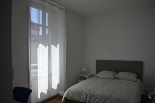 une chambre avec un lit et une grande fenêtre dans l'établissement Maison de ville 4 chambres à Cholet, Idéale pour les familles, groupes et sportifs !, à Cholet