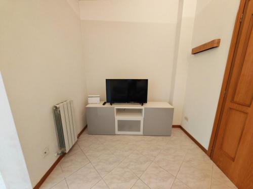 a room with a tv on a cabinet with a television at La Casina in Cecina