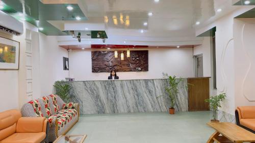 ダッカにあるHotel Dhaka City Innのロビーのカウンターに立っている女性
