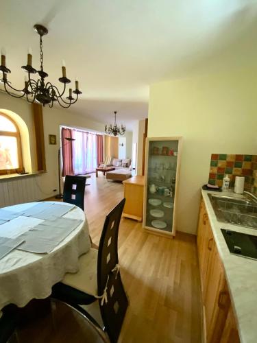 a kitchen and living room with a table and chairs at Heviz Gracia Apartment in Hévíz