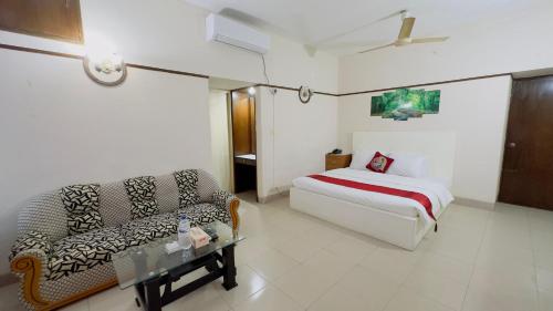 ダッカにあるHotel Dhaka City Innのベッドとソファのあるホテルの部屋