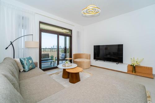 a living room with a couch and a flat screen tv at Peaceful 2BR Retreat Near Burj Al Arab in Dubai