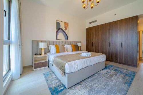 a bedroom with a large bed and a wooden cabinet at Peaceful 2BR Retreat Near Burj Al Arab in Dubai