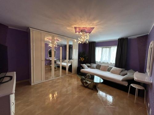 a living room with purple walls and a couch at Apartament zona 1 Decembrie in Tecuci
