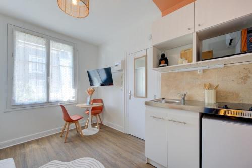 - une cuisine avec des placards blancs, un évier et une table dans l'établissement Urban - 800 m Gare- Hyper center - WiFi - Climatisé, à Tours