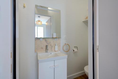 a white bathroom with a sink and a mirror at Urban - 800 m Gare- Hyper center - WiFi - Climatisé in Tours
