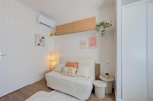 a living room with a white couch and a table at Urban - 800 m Gare- Hyper center - WiFi - Climatisé in Tours