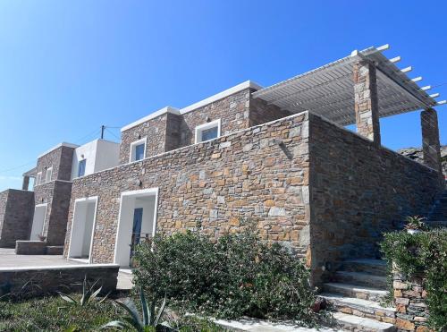 a brick house with a stone wall at Iliada Suites Simousi Kythnos in Kithnos