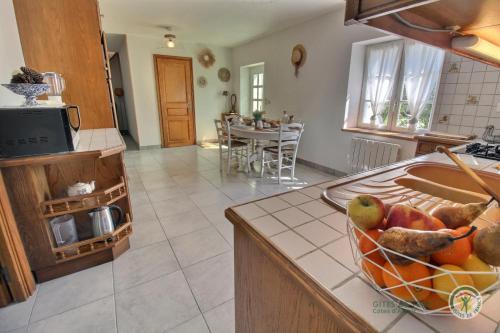 une cuisine avec un bol de fruits sur un comptoir dans l'établissement La fermette de la vallee, à La Chapelle-Neuve