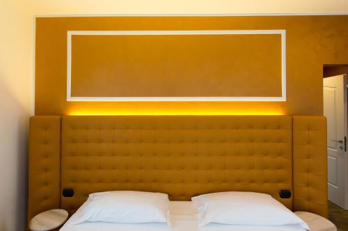 a bedroom with a bed with a yellow headboard at Hotel Al Campanile - Luxury Suites & Apartments in Baveno