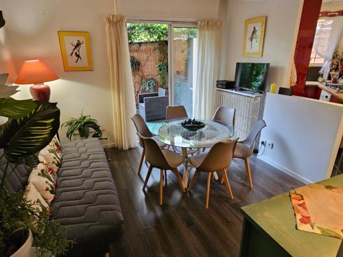 un salon avec une table en verre et des chaises dans l'établissement A 1 min de la plage! Bel appartement T4 avec petit jardin, à Fréjus