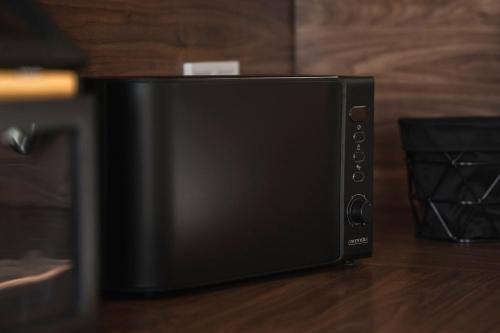 a black microwave oven sitting on top of a table at Ferienhaus zum Johannisthal in Hosena