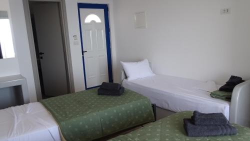 a room with two beds and a green ottoman at Hermes-Ios Rooms To Let in Ios Chora