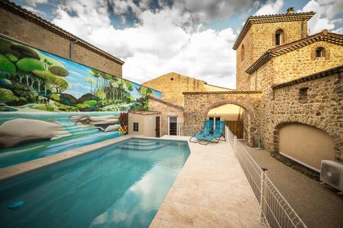 - une piscine avec une fresque murale sur le côté d'un bâtiment dans l'établissement Chez Janick & Hervé, à Lemps