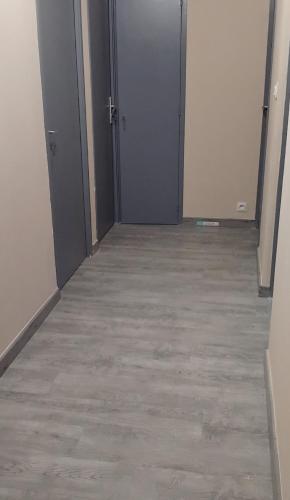 un couloir vide avec deux portes et du carrelage dans l'établissement Dordouce, à Marseille