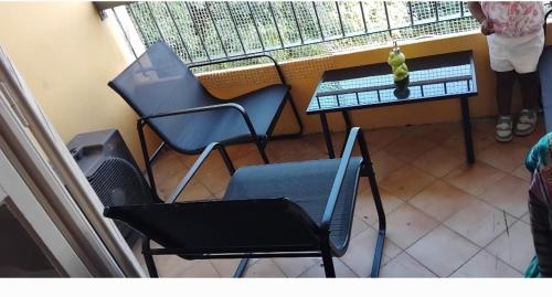 un balcón con sillas y una mesa con un pájaro. en Dordouce, en Marsella