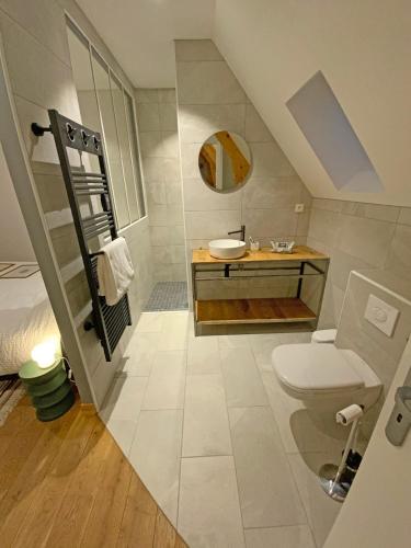 une salle de bain avec un lavabo et des toilettes dans l'établissement Grange Bernata, havre de paix sur la colline, à Pontacq