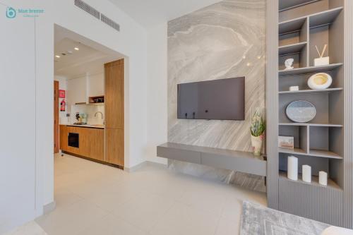 a living room with a tv on a wall at Bright & Luxury Studio with Balcony in Al Furjan in Dubai