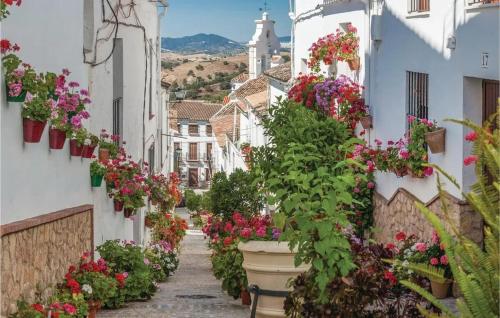 an alley with flowers in pots on buildings at Welcoming chalet with lake and mountain view - El Gastor in El Gastor