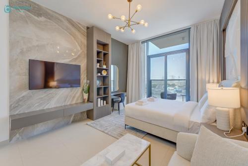 a bedroom with a king sized bed and a tv at Bright & Luxury Studio with Balcony in Al Furjan in Dubai