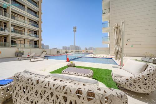 an apartment patio with two lounge chairs and a pool at Bright & Luxury Studio with Balcony in Al Furjan in Dubai