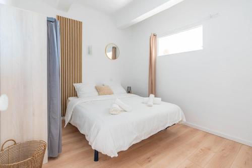 a white bedroom with a white bed and a window at Appartement spacieux, chaleureux & tout confort in Pertuis