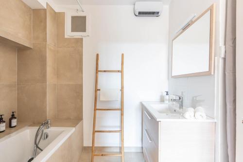 a bathroom with a tub and a sink and a ladder at Appartement spacieux, chaleureux & tout confort in Pertuis