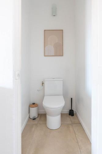 a bathroom with a toilet with a picture on the wall at Appartement spacieux, chaleureux & tout confort in Pertuis
