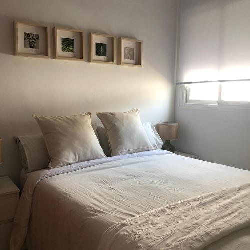 a bedroom with a large bed with white sheets and pillows at Apartamento Relax Centro in Sanlúcar de Barrameda