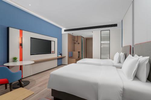 a hotel room with two beds and a flat screen tv at Holiday Inn Express Kunming Economic Dev Zone by IHG in Kunming