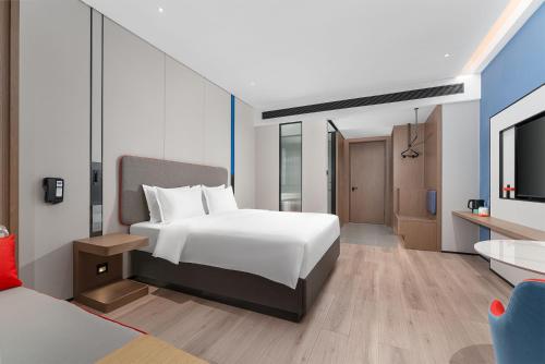 a bedroom with a white bed and a tv at Holiday Inn Express Kunming Economic Dev Zone by IHG in Kunming