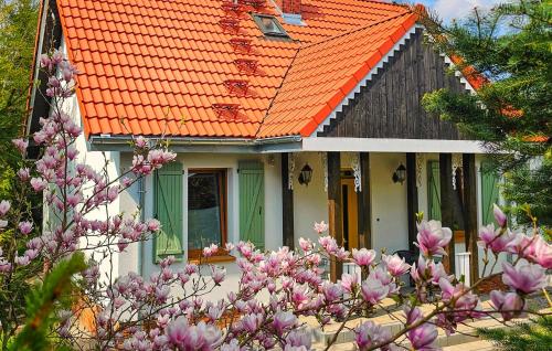 an orange roofed house with pink flowers in front of it at Beautiful Home In Podwilczyn With Sauna in Dębnica Kaszubska