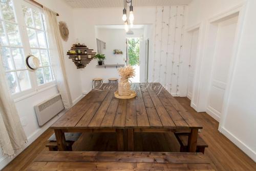 - une salle à manger avec une table en bois dans l'établissement Maison du Soleil Atypique, à Biscarrosse