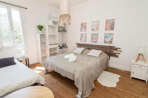 une chambre blanche avec un lit et une grande fenêtre dans l'établissement Maison du Soleil Atypique, à Biscarrosse