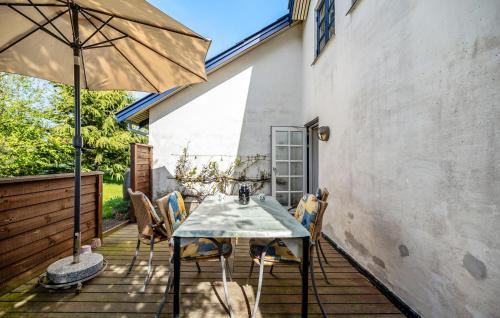 a patio with a table and chairs and an umbrella at 3 Bedroom Cozy Home In Store Fuglede in Store Fuglede