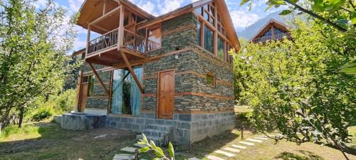 une maison avec un balcon sur le côté dans l'établissement Shantchit Wellness Resort Hotel in Kasol Valley, à Kasol