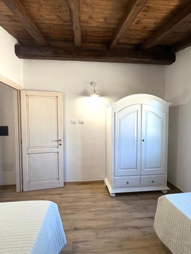 a bedroom with two beds and a white cabinet at Orosei Summer Holidays - Cala del Turco green house in Orosei