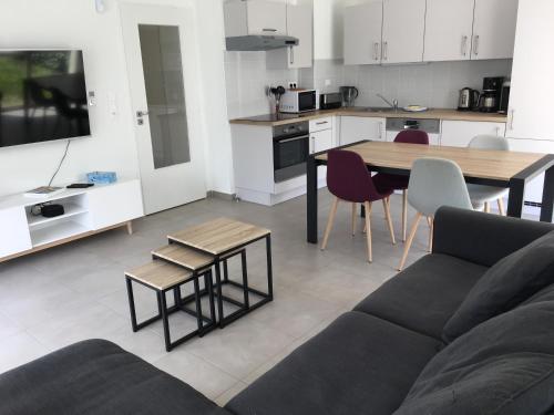 un salon avec un canapé et une table et une cuisine dans l'établissement appartement proche de la plage , wimereux , 2 chambres , box stationnement , wifi, à Wimereux