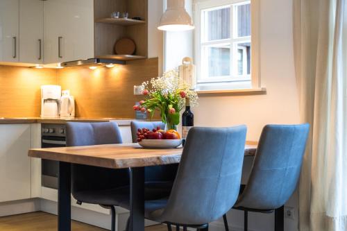 a kitchen with a wooden table and blue chairs at Heide Ferien - Hof Bockelmann in Bispingen