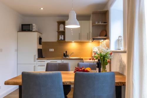 a kitchen and dining room with a wooden table and chairs at Heide Ferien - Hof Bockelmann in Bispingen