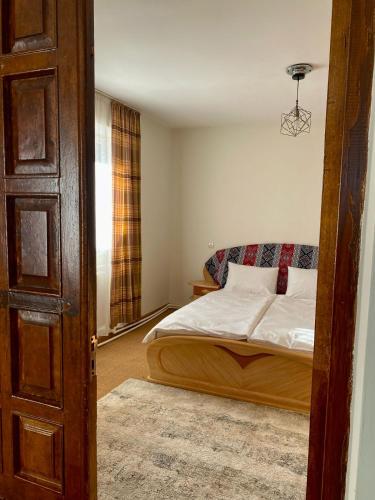 a bedroom with a bed with white sheets and a window at Gudauri Deka House in Gudauri