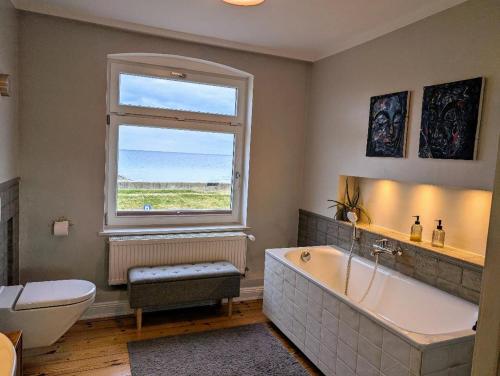 a bathroom with a large tub and a window at Haus am Meer- Traumhafter Meerblick in Dahme