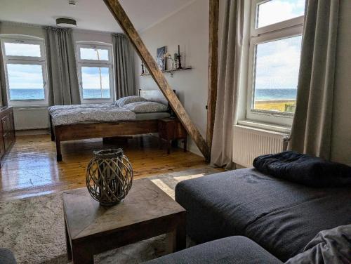 a room with two beds and a table and windows at Haus am Meer- Traumhafter Meerblick in Dahme