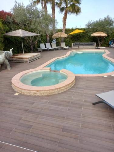 - une piscine dans un complexe avec des chaises et des parasols dans l'établissement Villa La Lauzade, au Luc