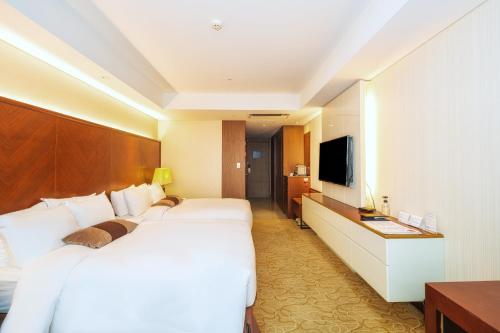 a hotel room with two beds and a television at Koreana Hotel in Seoul