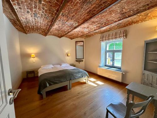 a bedroom with a bed and a wooden floor at Les Gîtes du Château de Bellaire in Gesves