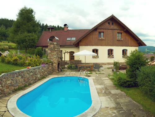 a house with a swimming pool in front of a house at B&B Na kopečku in Rokytnice nad Jizerou