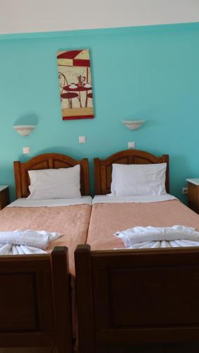 two beds sitting next to each other in a room at Hermes-Ios Rooms To Let in Ios Chora